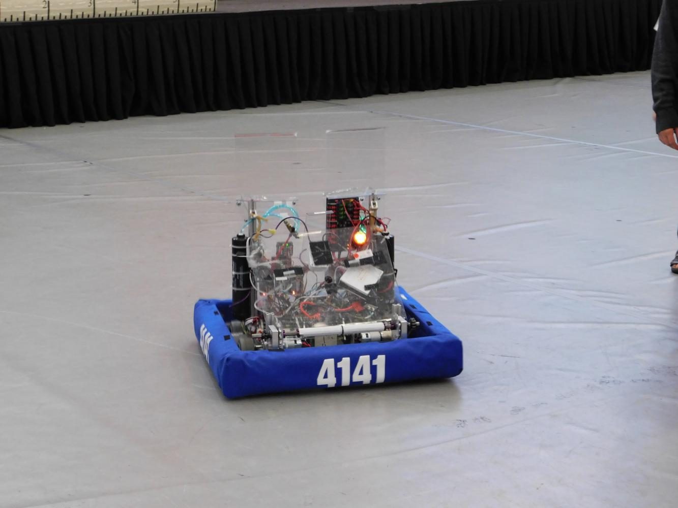 The Robotics Team walk with their robot. 