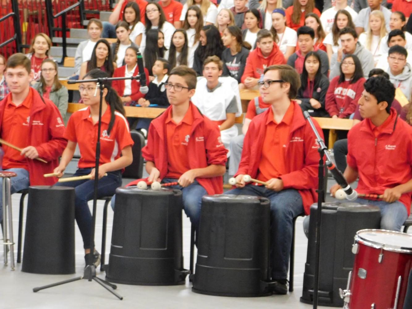 The band, under the leadership of Dylan Ly, creates a piece using only buckets and cans. 