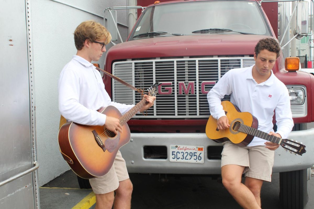 Seniors Jake Armstrong and Vincent Pozzuoli play guitar outside of the band room during the block 4 elective, Guitar Media Production.