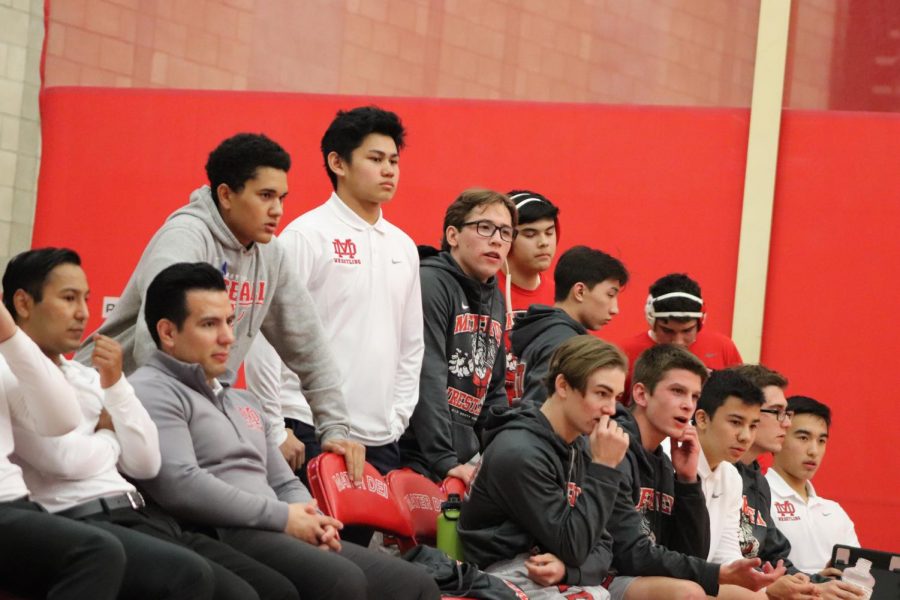 WRESTLING TEAM JOLINS TOGETHER TO SUPPORT SENIORS: The wrestling team anxiously watches their teammates complete against Estancia High School  on Jan. 23. The team cheers on their senior classmates to celebrate the programs senior night.