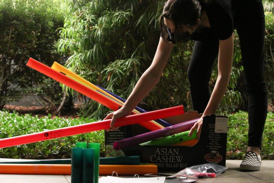 MIX AND MATCH: Hunched over, senior Natalie Erhard organizes the Boomwhackers into piles. Erhard separates them in order to easily identify which instrument plays what note. ”Music to me is a way for people to come together and express their art. Its really just a place for artists to come together, tell stories, and just entertain others and give them an escape from whatever is going on in life,” Erhard said.