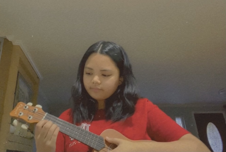 PRACTICE MAKES PERFECT: Sophomore Roecel Sangrador practices playing her ukelele, which she has been working to perfect during quarantine. For students, including Sangador, quarantine has left a plethora of time and many use that time to better their skills in different areas. “I have had a ukulele laying around...I [hadn’t] really had time aside to play it and quarantine gave me the time and chance to.”