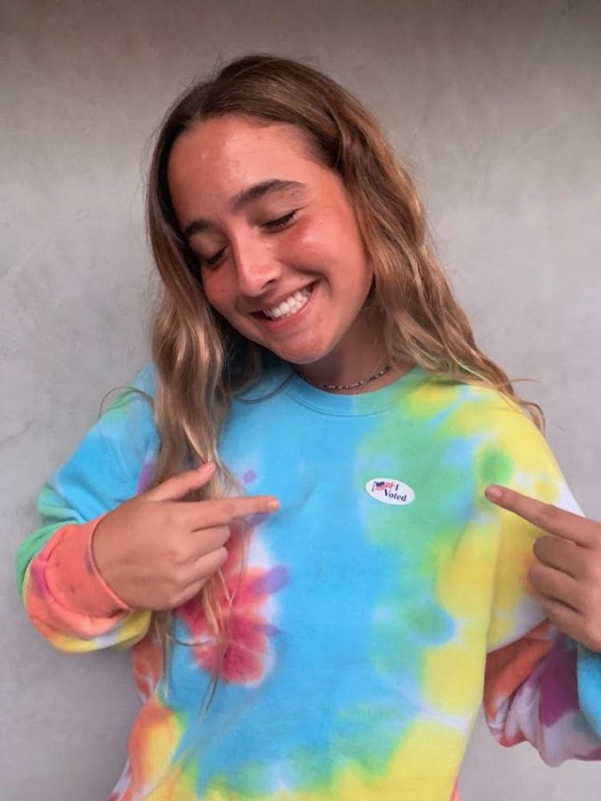 USING HER VOICE: Senior Taylor Bruder poses with her “I Voted” sticker after voting in the 2020 U.S. Presidential Election. Bruder posted her photo to her Instagram story to promote awareness of the election, which will take place on Nov. 3. “I’m going to vote because I’m concerned about our country,” Bruder said. “People’s rights are on the line. I’m voting to protect my rights and other minorities rights.”