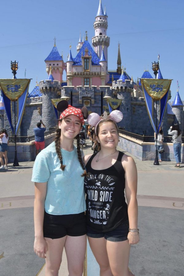 THE HAPPIEST PLACE ON EARTH: Senior Rachel Dennin and older sister Melissa pose in front of the Disneyland castle on one of their many trips to the theme park. Like many, Dennin misses the feeling of going to Disneyland. “I just miss being in that environment and hearing the music and walking down Main Street, Dennin said” (Photo courtesy of Rachel Dennin) 
