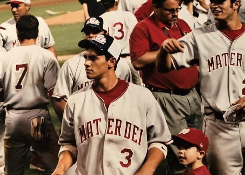 A FAMILY AFFAIR: 2 year old Cade O’Hara stands next to half-brother, 18 year old Michael Torres after the 2005 Mater Dei baseball team wins the CIF Championship. 16 years on, O’Hara now wears that same uniform, representing Mater Dei. Torres has continued to be both his coach and role model. “He has developed the player that I am today and the game that I play today,” O’Hara said. “And as a person, I’ve always watched him when we were out in public. I’ve watched how he’s treated other people. He’s always been super nice and caring.”