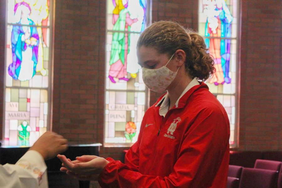 REMEMBERING AND REFLECTING: Senior Anna Campbell receives the Eucharist during the 9/11 Remembrance Mass on Friday, Sept. 10. She, like all other current high school students, was not alive on Sept. 11, 2001, but joined the MD community in gathering to remember those who lost their lives during the attack and reflect on the event through prayer.