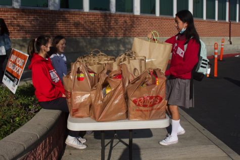 IT STARTS WITH THE STUDENTS: Campus Ministry commissioners, sophomores Angelin Tran (far left) and Hailey Mouat (second from the left), take their turn volunteering before school to collect donations for Thanksgiving Outreach on Wednesday, Nov. 10. “I think it’s important to be able to use the privilege that we have to give to others who are less fortunate,” Mouat said. (Photo courtesy of Brigette Ramirez) 