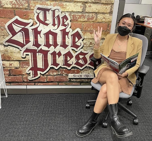 WORKING FOR THE PRESS: Kristen Castillo ‘18 sports Arizona State University’s signature “forks up” sign in The State Press newsroom. After graduation, Castillo chose to join The State Press as a staff reporter, and appreciates the experience she received while at Mater Dei. “[Running a newspaper in college] is the same exact situation,” Castillo said. “[The newspaper] is completely student run. We are at the expense of our peers, which is really cool.” 
