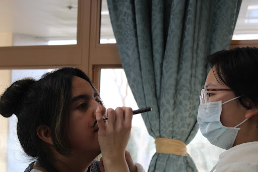 PLAYING A ROLE: Sister Charis (right) of Heart of Jesus Retreat Center applies costume makeup for Sacred Heart Kids Club Staff for a video. Staff members are expected to participate in Kids Club events, including videos, skits, games, and other activities. These activities help the kids understand the topics being discussed, such as the seven sacraments and their purposes, and set examples for the kids. “You get to work with [people] your own age, and it’s really just tons of fun,” Sister Paula said. 