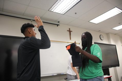 WITNESS SWEARS IN Sophomore attorney, Angela Karanja, temporarily plays the role of bailiff to swear in Junior witness, Anthony Laguna, during a mock trial scrimmage for the Gray Team. To ensure that witnesses do not lie or make up scenarios that are not from the case packet, they swear to tell the complete truth in both their direct and cross examinations. “My favorite part of mock trial is the experience of learning how a real court case works with my friends, and people I look up to,” Karanja said.