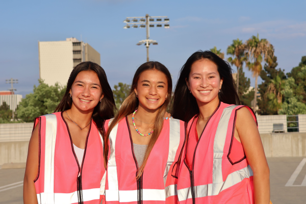 MONARCHS IN PINK Freshmen Brooklyn Almasi, Rachel Koch, and Jeanette Schulz smile into the camera before the big game at the Freshman Tailgate. The annual Freshman Tailgate, hosted on Friday, Sept. 20, at the top of the parking structure at Santa Ana Stadium, was a big hit. The Freshman Commissioners and Freshman Officers organized the event with fun games, various raffles, and catered Chick-fil-A. Not only did the freshmen have a great time, but the organizers felt fulfilled with their efforts. “The best part [is when] we get to [organize] rallies or plan events,” Freshman President Sophia McKay said. Photo courtesy of Abby Abad.