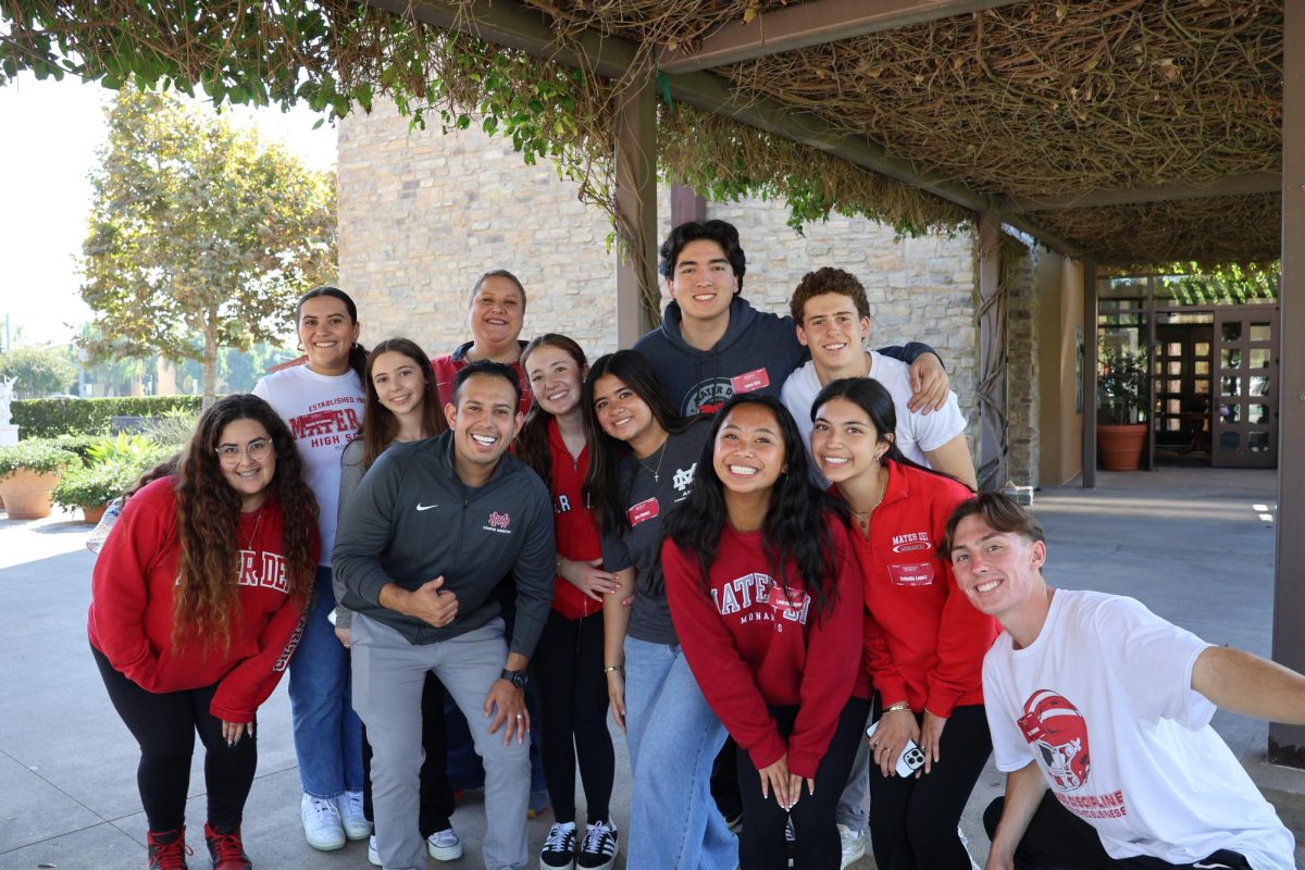 GROWING TOGETHER IN FAITH The Mater Dei retreat team poses for a photo after completion of the first Freshman Retreat of the year. These leaders came together to run small groups, activities, and give testimonies to exemplify the values of Honor, Glory, and Love. They not only help the freshmen grow in faith, but grow closer together in friendship. “My favorite part is building my relationships with the other retreat leaders,” Wickwire said. Photo courtesy of Campus Ministry. 
