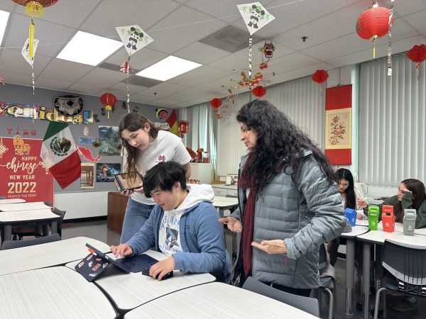 GUIDING THROUGH LANGUAGE Senior Jay Qiu seeks guidance from Zeyda Marsh, World Language Department Chair and Teacher, during office hours as he refines his class project for Chinese class. “Office hours allow me to ask specific questions and improve beyond what we cover in class,” Qiu said. “Having this one-on-one time with my teacher is really helpful.” Marsh always tries to create a collaborative and supportive environment in her office hours to help deepen students’ understanding and create opportunities for students in Honors Chinese. “We use one of the two office hours on Thursdays for Chinese tutoring clubs,” Marsh said. “Students who need to be tutored can come to be tutored by other students.”