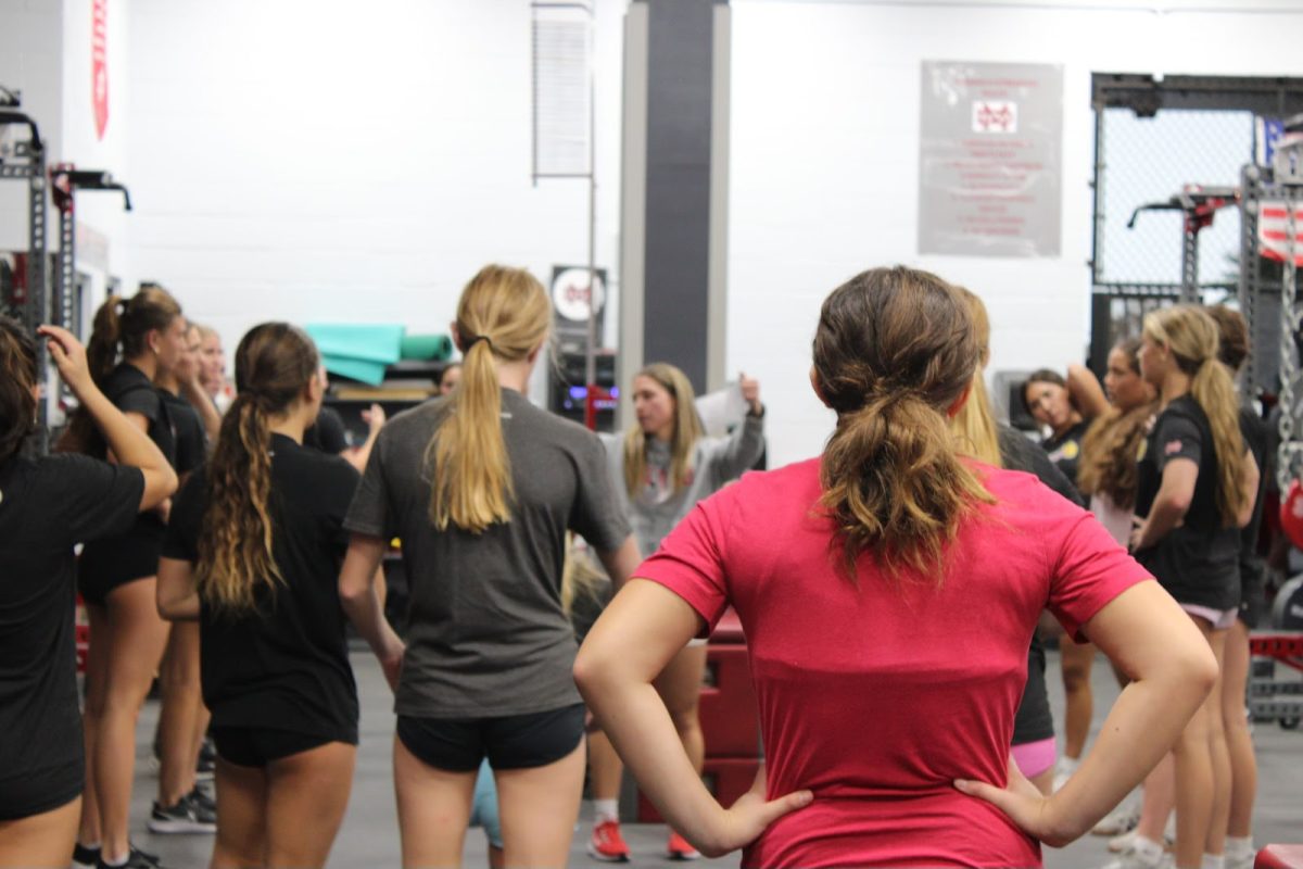 PROGRESS–ONE LIFT AT A TIME Strength Coach Reagan Appleby instructs Varsity Girls Water Polo as they prepare to begin their weight training. After the recent changes, athletes have responded well and continue to work hard. “I feel like we've struggled when we haven't enforced discipline,” Appleby said. “Now that we have a standard and rules that they have to go by, there's less showing in the [wrong] attire, and less showing up late.”