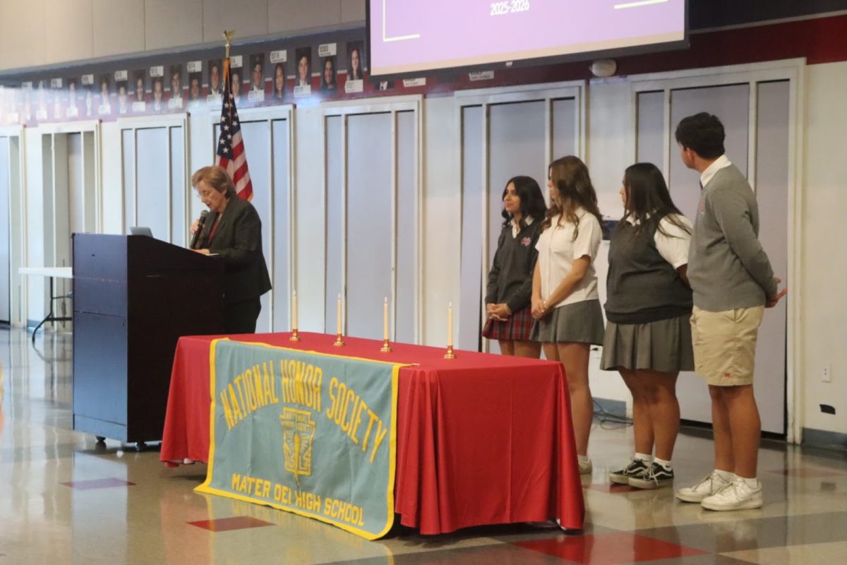 NATIONAL COMMITMENT Mater Dei Principal Frances Clare gives a speech to the newly inducted NHS students on the roles they must commit to as an extension of the school. Students who joined the NHS are to lead with Honor, Glory, and Love. Jack Champion, a 4.0 scholar, feels really fortunate that NHS is possible at his school. “It's really helpful for students in need of scholarships,” sophomore Champion said. Photo by Ella Ryan. 