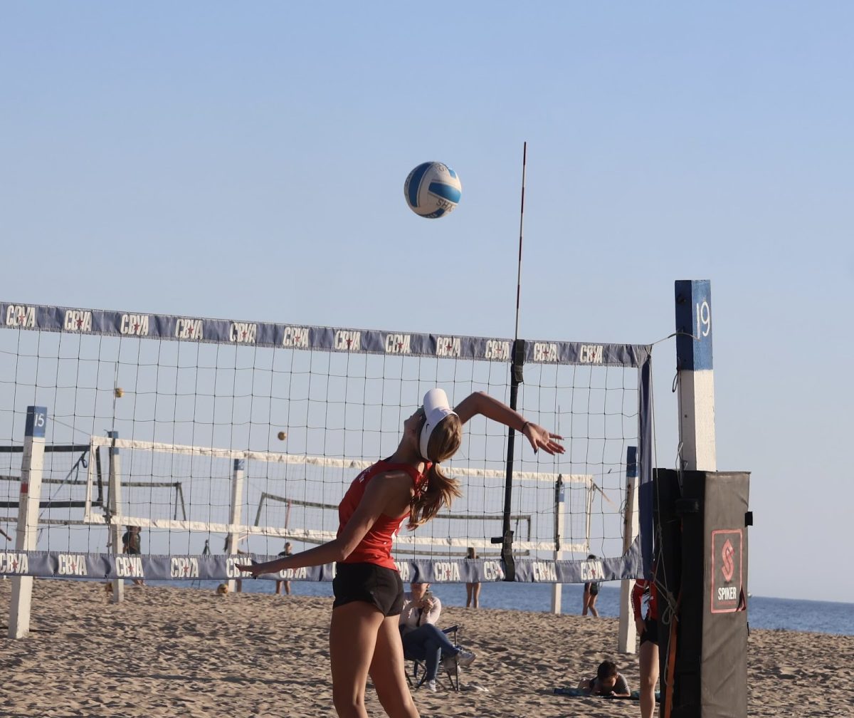 SERVE’S UP Sophomore Scarlett Dickerson serves a ball over the net. On Feb. 26, Mater Dei’s Girls Beach Volleyball Team went against Fountain Valley High School. Dickerson explains the athletic ability needed for this sport and the difference between beach and indoor volleyball. “You need to be explosive to jump higher in the sand, and you need to be getting [most] of the balls because there's only two people on the court,” Dickerson said.