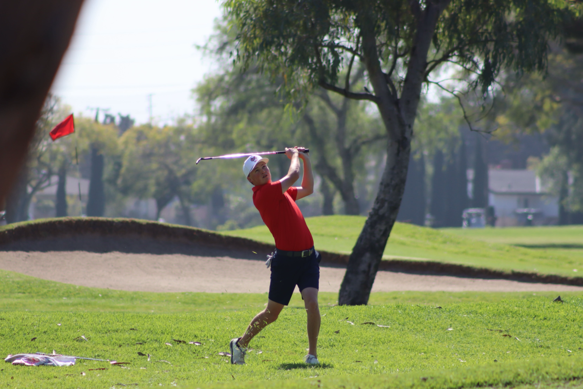 EYES ON THE FAIRWAY Senior Griffin Vaughan watches his ball fly after a powerful follow-through during a Trinity League match against St. John Bosco. On March 11, the Monarchs showed off their hard work and discipline as they continued to push for a league title. To stay focused during a really difficult schedule, Vaughan relies on the "great community" of the golf program and the hard work he sees from his teammates every single day. “The entire program gets along, works together, and practices with the team and on their own,” Vaughan said. Photo courtesy of Angela Liu.